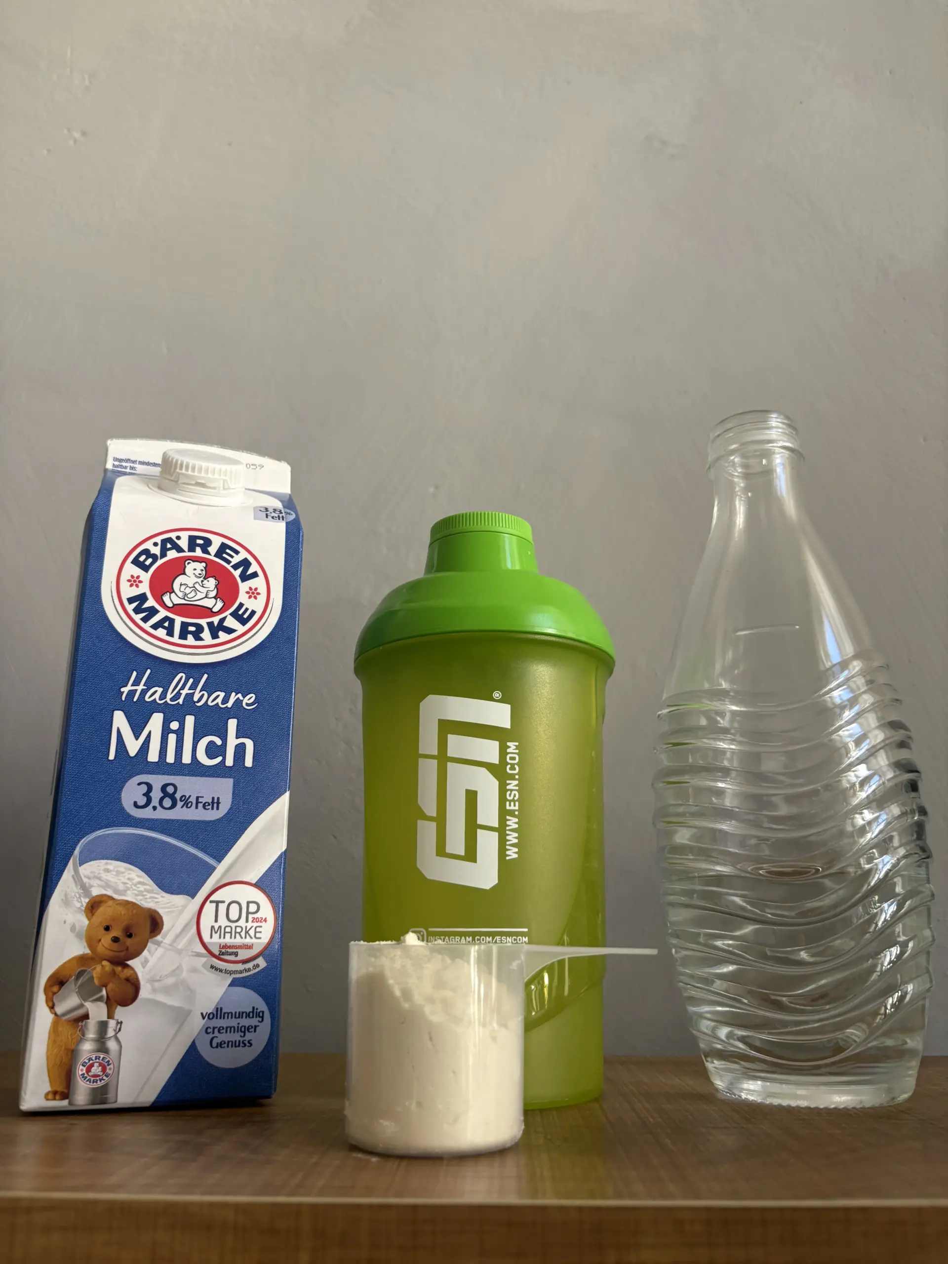 Proteinshake mit Wasser oder Milch mit Proteinpulver Milchtüte und Wasserflasche