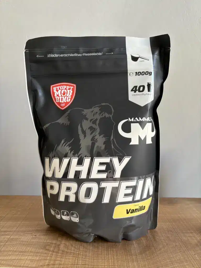 Eine 1 KG Verpackung vom Mammut Whey Protein in der Sorte Vanille steht auf einem Tisch