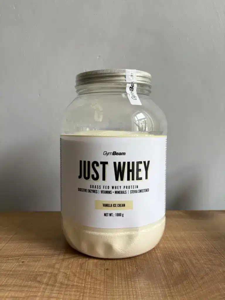1 kg GymBeam Just Whey Dose auf einem Tisch