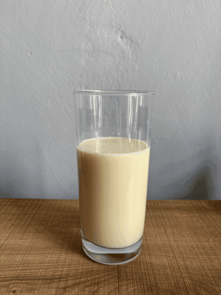 Olimp Whry Protein Complex 100 % mit Wasser und einem Shaker zubereitet in einem Glas